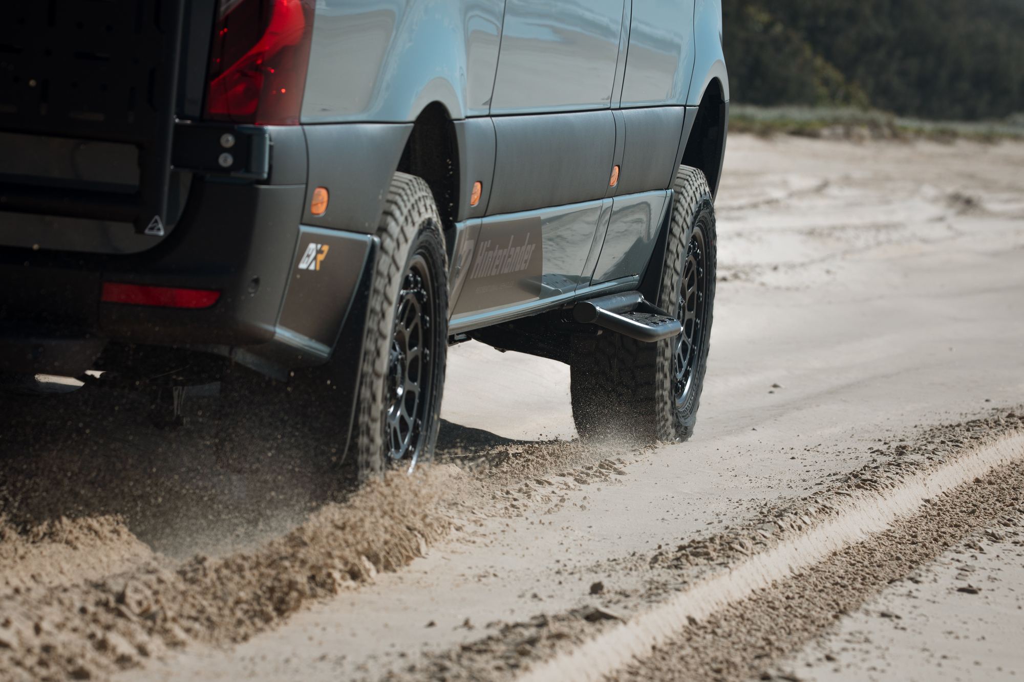 A Hinter Vans Sprinter driving through soft sand